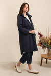 Woman wearing a navy coat standing in a room equestrian fashion outfitters 