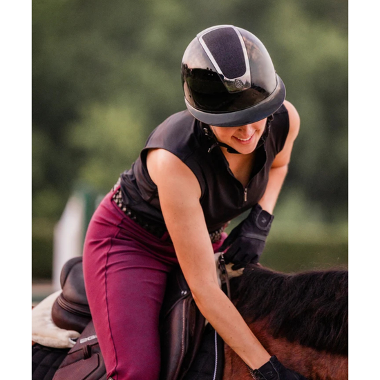 someone riding. horse with a black glossy shiny helmet with a shiny shimmer sparkly top panel equestrian fashion outfitters