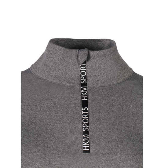 A close-up of a dark gray heathered athletic top featuring a mock neck collar and a vertical black zipper pull with white text reading 'HKM SPORTS HKM SPORT'. equestrian fashion outfitters