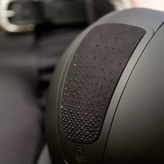 Close-up of black glitter black riding helmet with a blurred background