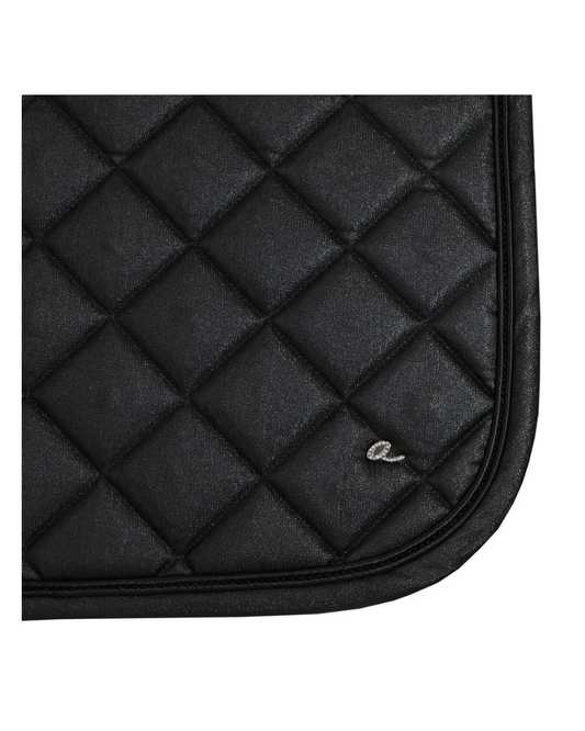 Close-up of a black quilted saddle pad with diamond stitching and a small silver embroidered logo, shown on a white background. equestrian fashion outfitters