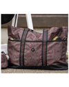 A large tote bag with a brown and red paisley & horseshoe pattern, black trim, and dual shoulder straps, shown outdoors next to a matching small pouch. equestrian fashion outfitters