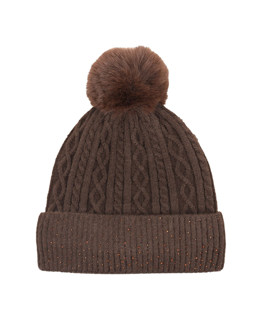 A brown cable-knit beanie hat with a matching faux-fur pom-pom on top and a ribbed cuff decorated with small multicolored glitter specks, shown against a plain white background. equestrian fashion outfitters