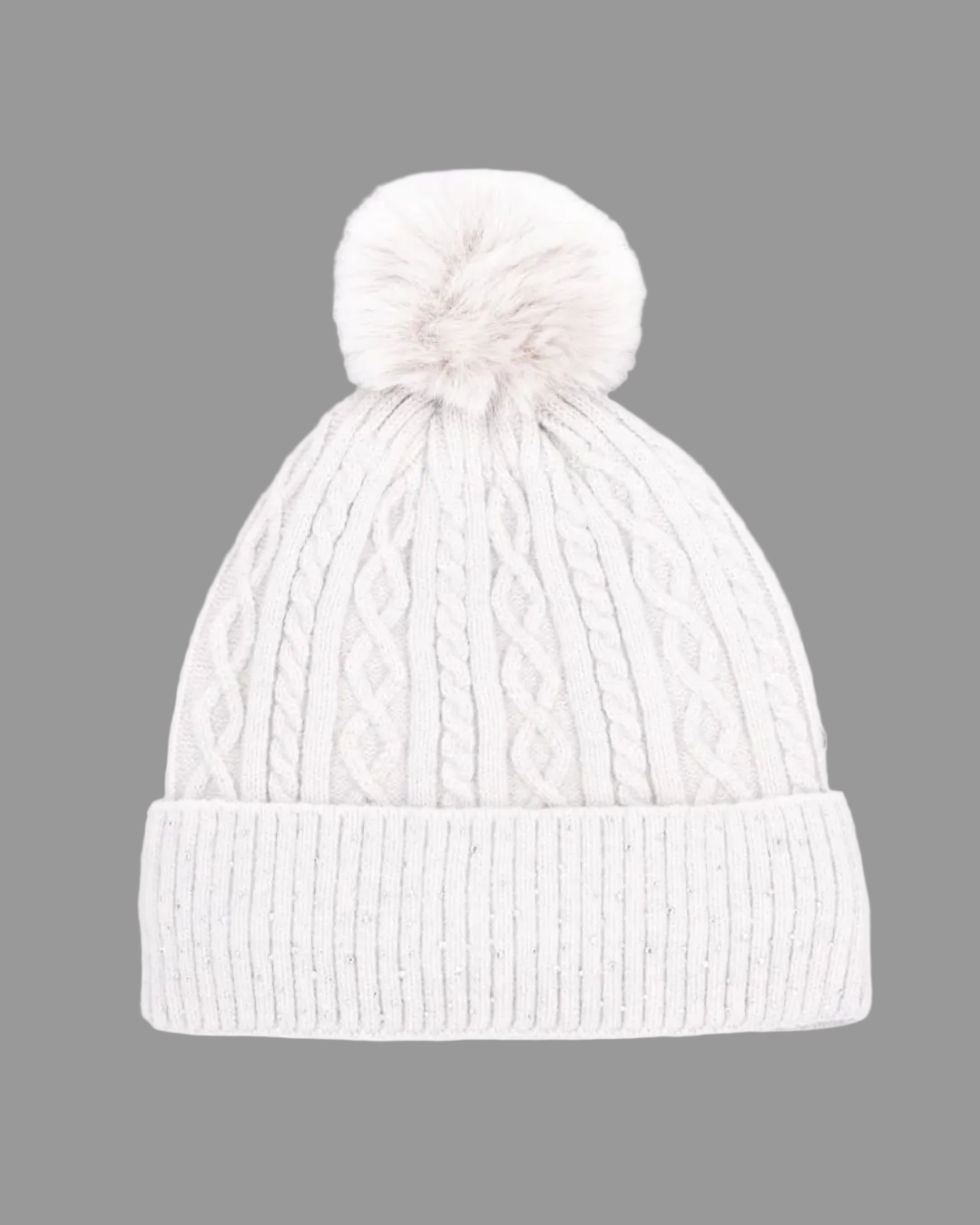 A white silver cable-knit beanie hat with a matching fluffy pom-pom on top and a ribbed folded cuff, shown against a plain white background. equestrian fashion outfitters