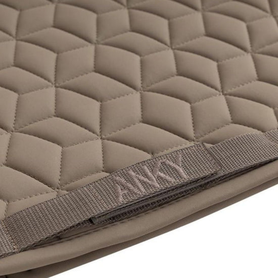 Quilted beige khaki pad with a strap featuring the brand name Anky on a white background